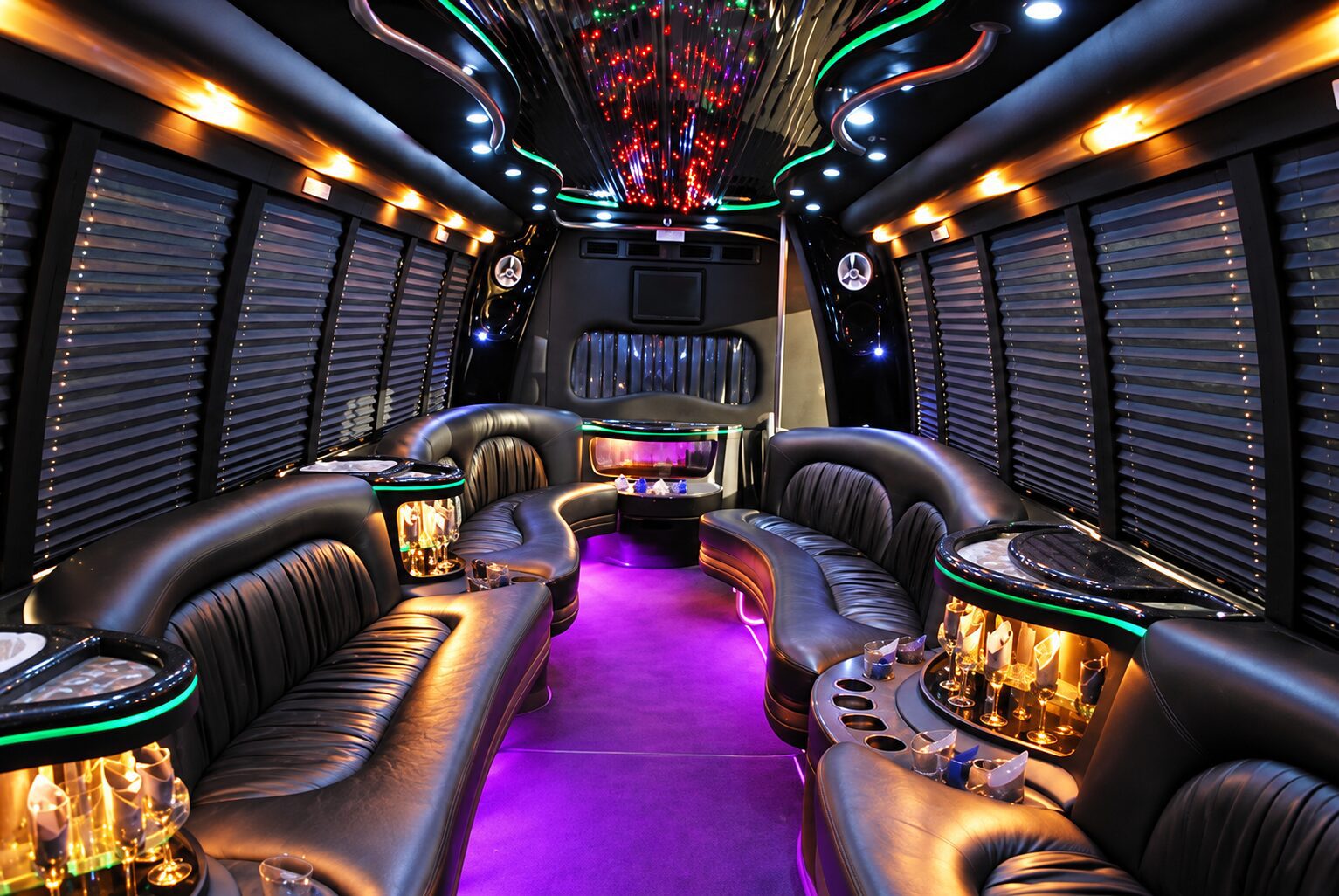 Party bus interior with black leather seating and colorful lighting for Chicago weddings and suburb transportation